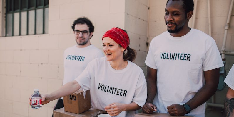 2 men and a woman working for charity in Africa
